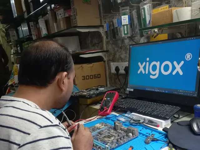 Technician probing a computer motherboard with a multimeter and soldering iron