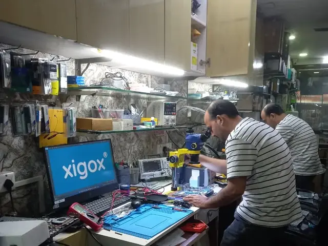 Xigox technician at the repair bench working on a computer board