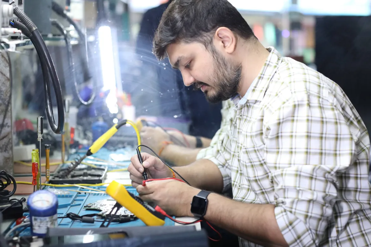 Xigox technician working on a laptop board at the Virar West repair workshop (photo 10)