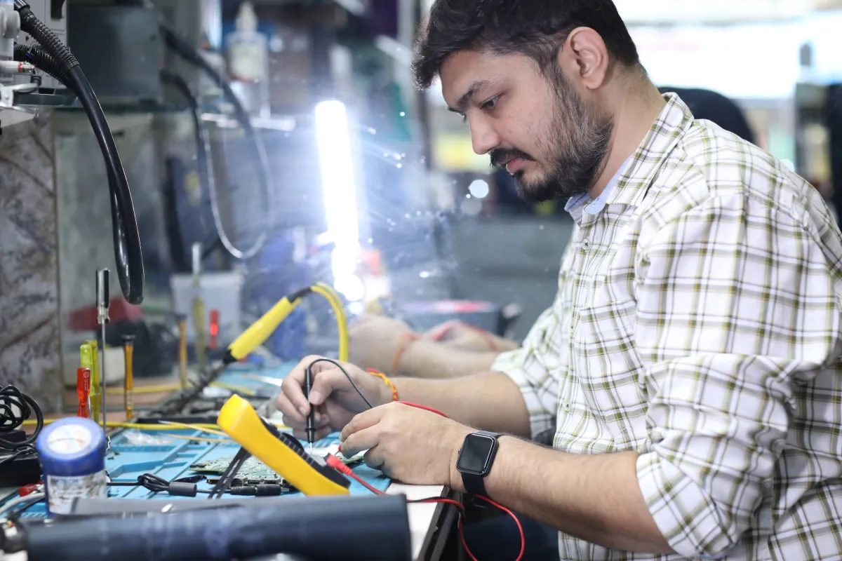 Xigox technician working on a laptop board at the Virar West repair workshop (photo 11)