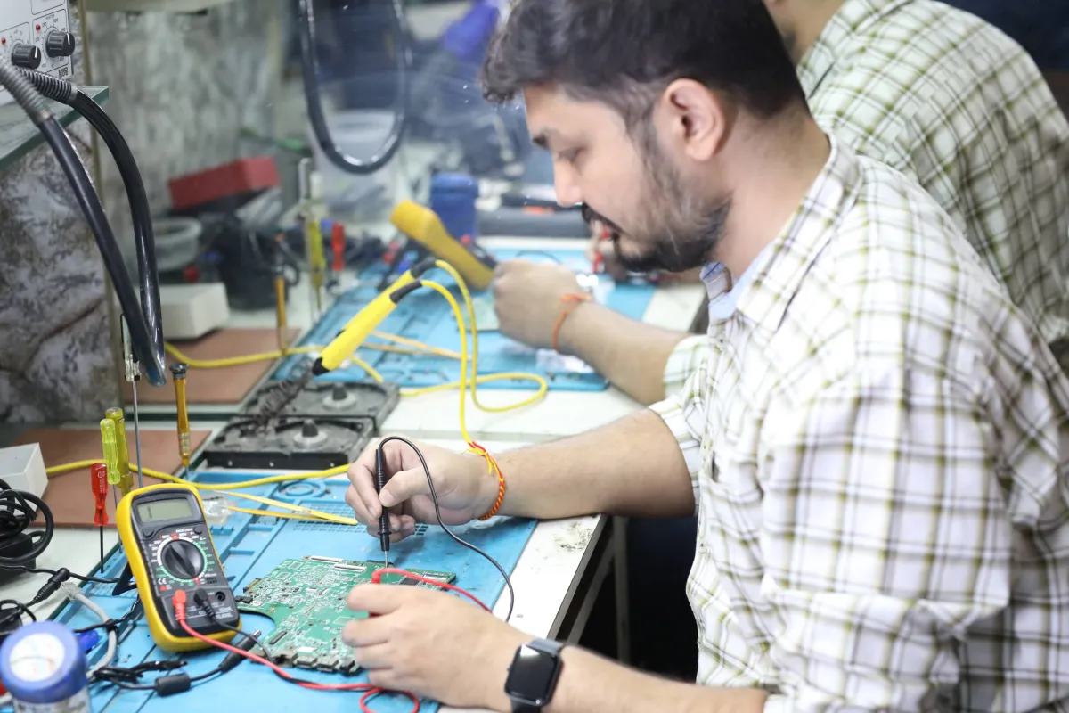 Xigox technician working on a laptop board at the Virar West repair workshop (photo 12)