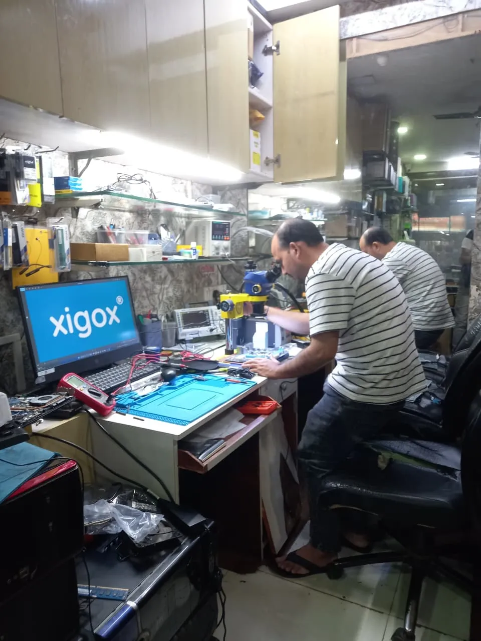 Xigox technician working on a laptop board at the Virar West repair workshop (photo 6)