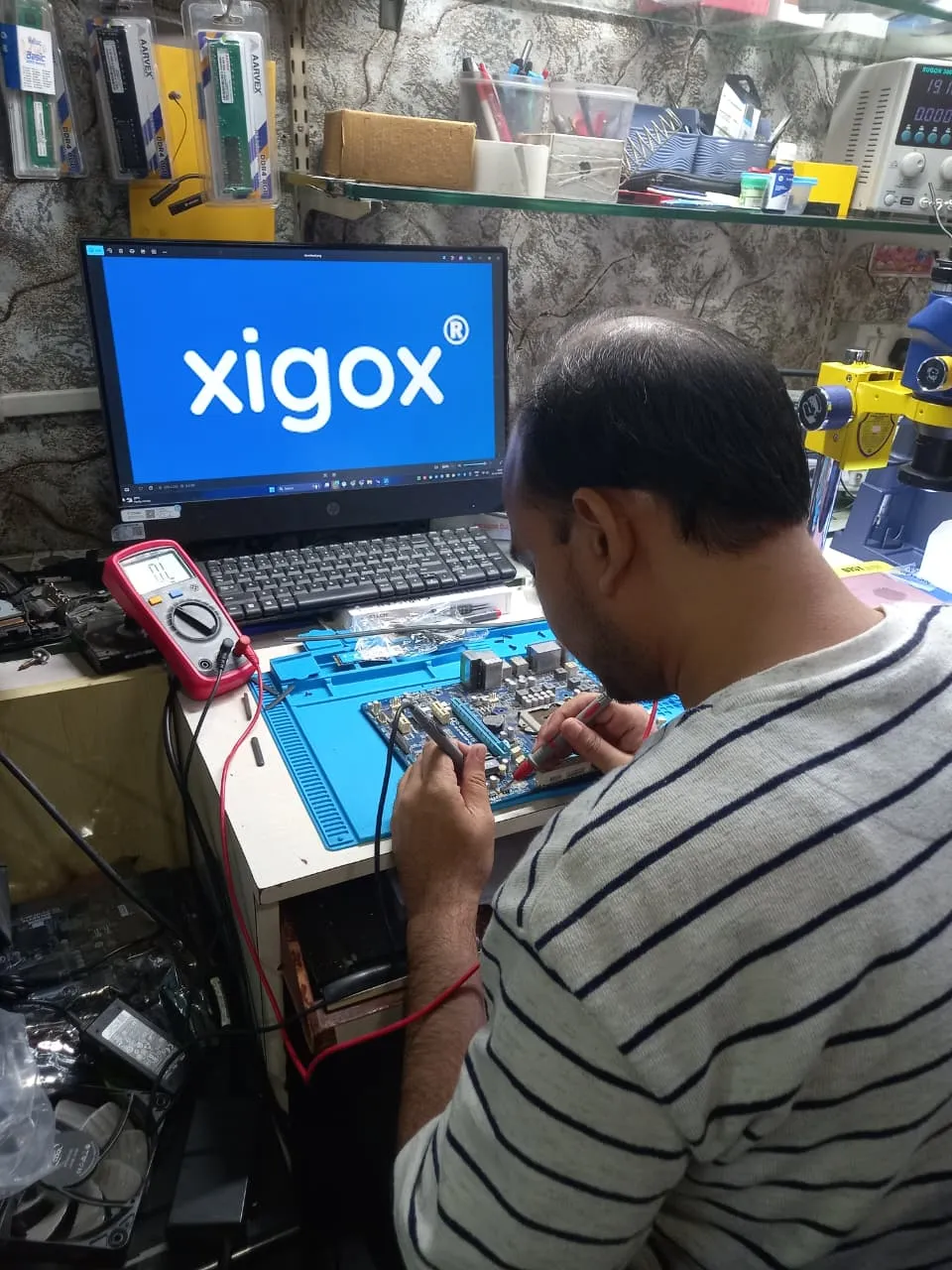 Xigox technician working on a laptop board at the Virar West repair workshop (photo 2)