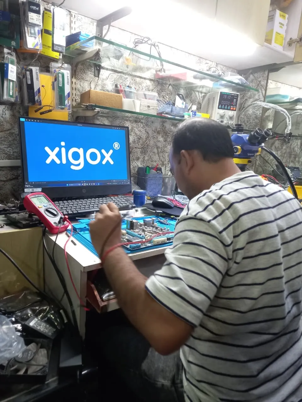 Xigox technician working on a laptop board at the Virar West repair workshop (photo 1)