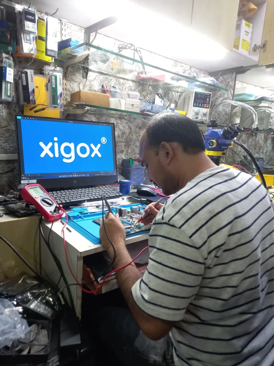 Xigox technician working on a laptop board at the Virar West repair workshop (photo 2)